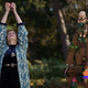A woman reaches for the sky next to a very strange sculpture topped by a baby doll in Shudder's Slasher: Flesh & Blood.